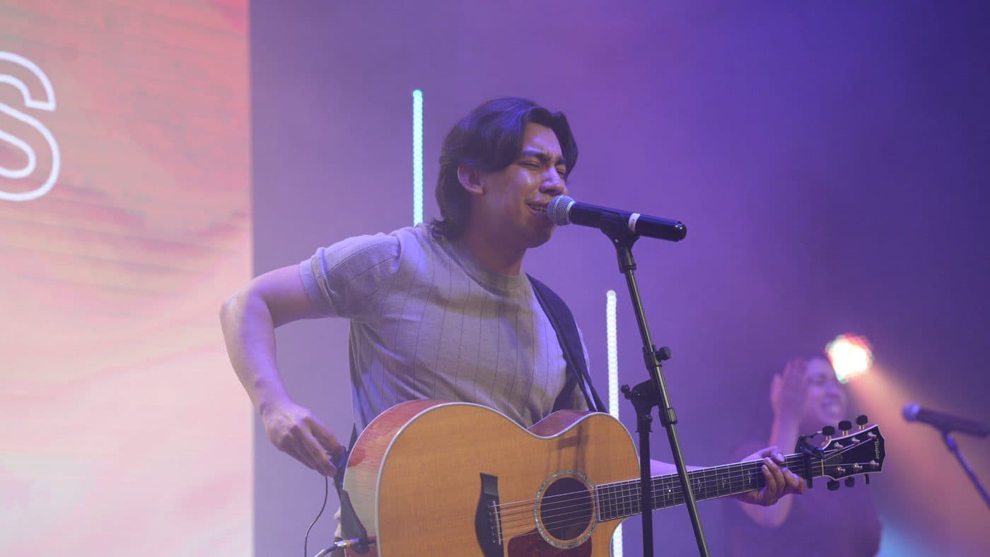 Juan Poumian cantando con su guitarra acústica sobre el escenario
