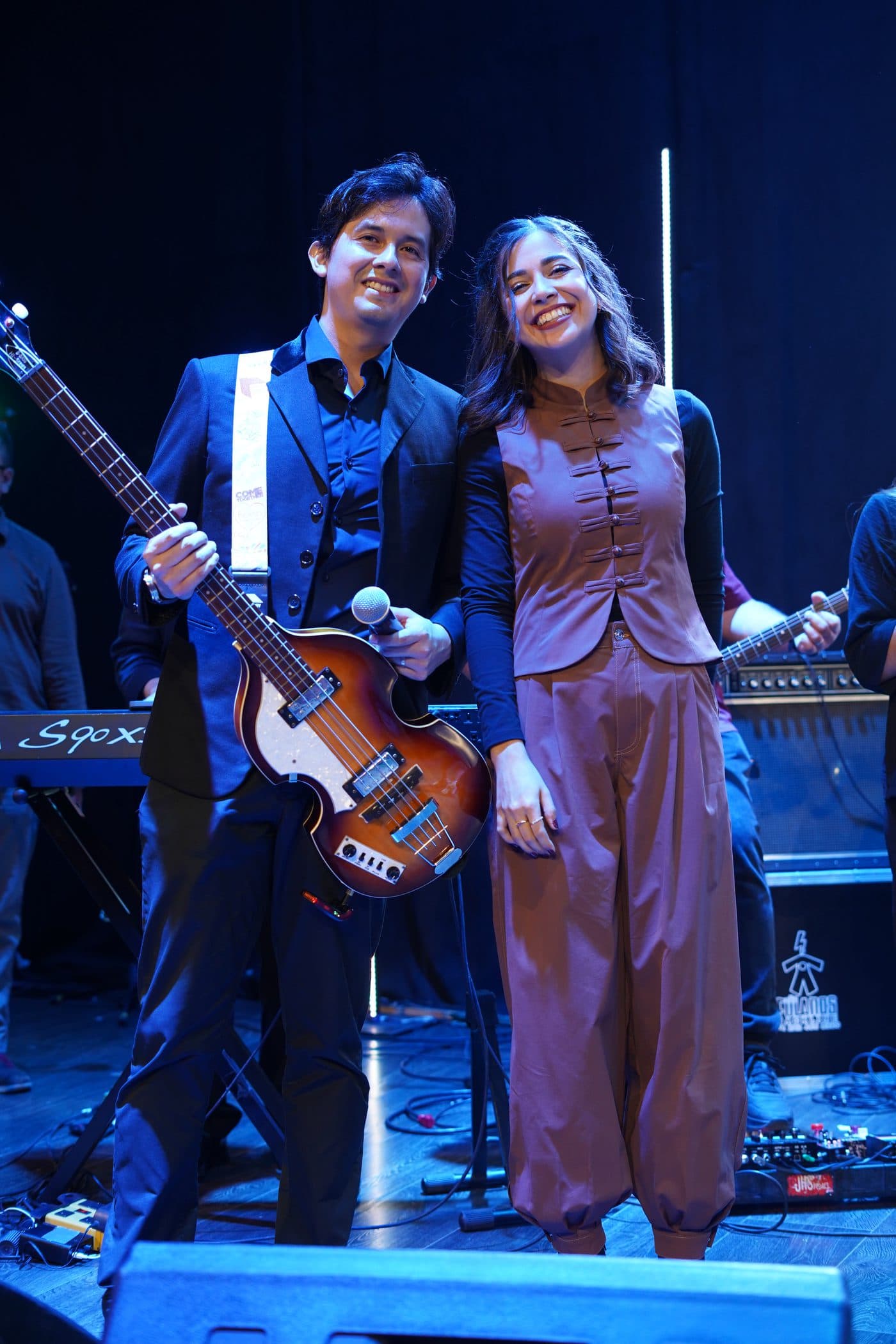 Aldo y María Teomitzi, de Songfield, sonriendo juntos en el escenario con un bajo